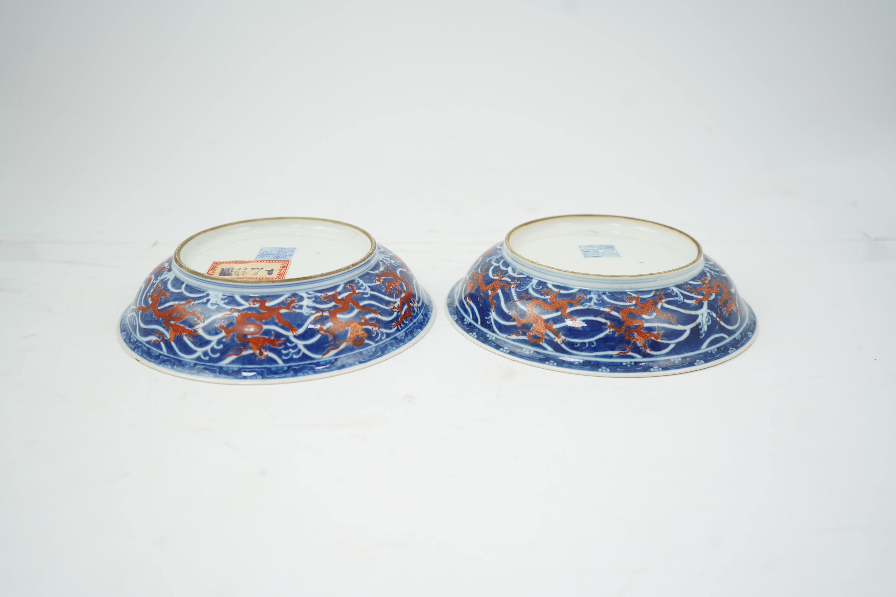 A pair of Chinese iron red and underglaze blue ‘dragon’ dishes, Qianlong seal mark and of the period (1736-95)
